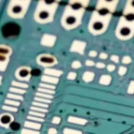 Close up of a green bare printed circuit board with an ENIG finish.