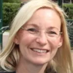 Head shot photo of Vicky, our sales manager. Long blonde hair, wearing thin rim glasses. Vicky is smiling with her head tilted to one side.